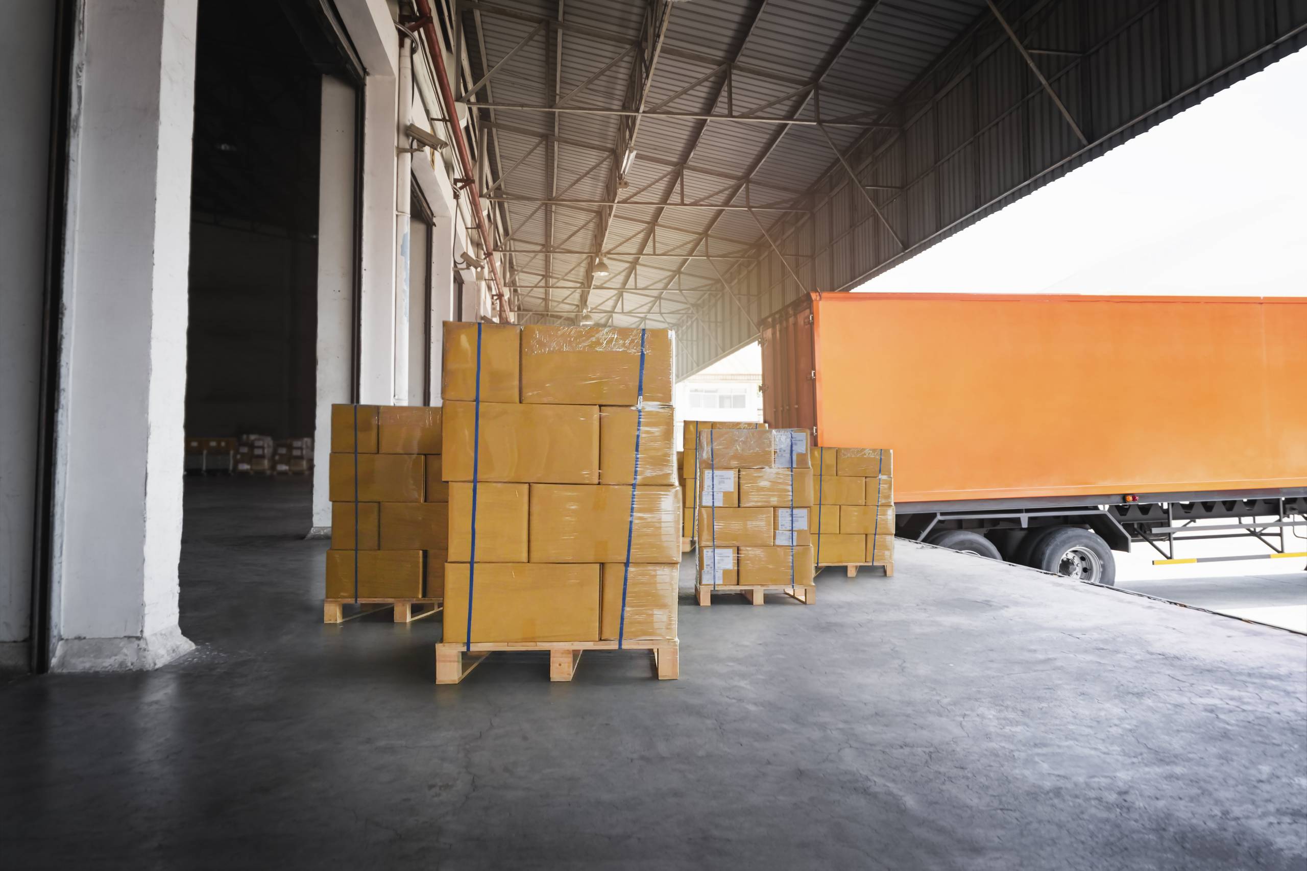packaging-boxes-stacked-pallets-loading-with-shipping-cargo-container-freight-trucks-logistics